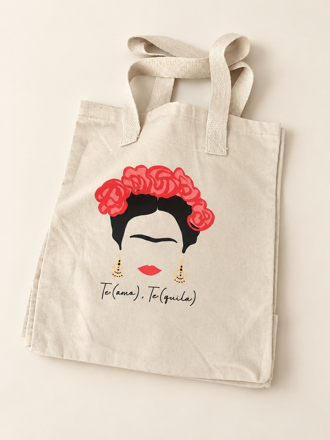 Bolsa clara con ilustración de Frida, flores rojas y el texto Te(amo), Te(quila), sobre fondo claro.