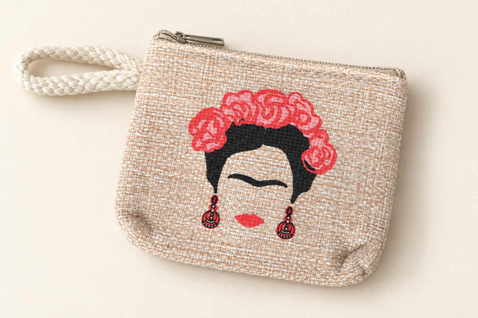 Monedero con cremallera, asa y una ilustración de Frida con flores rojas y pendientes rojos y negros.