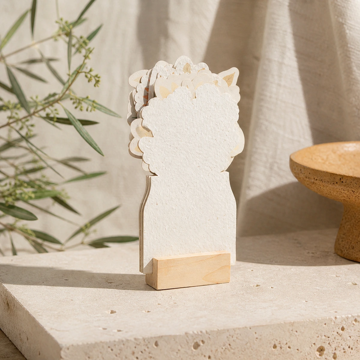 Calendario floral con hojas plantables y base de madera, presentación en un entorno natural.