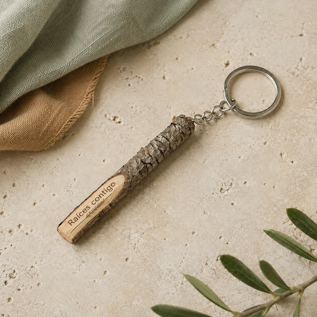 Llavero de rama de madera con grabado personalizado; propuesta de grabado láser con la frase «Raíces contigo» en una composición de tonos naturales.