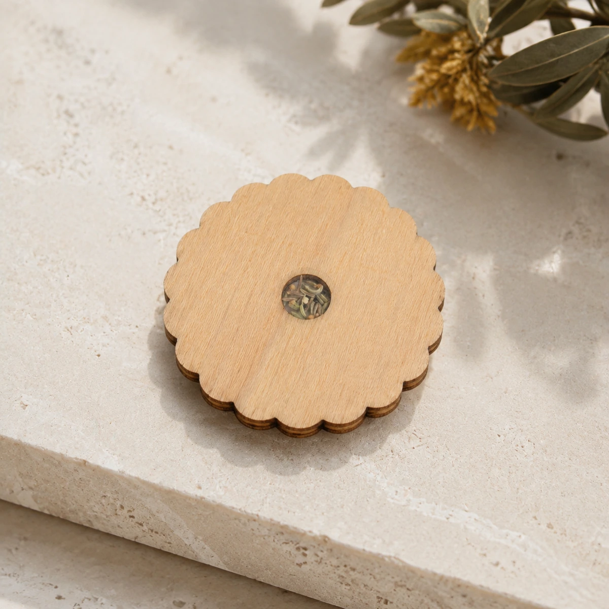 Posavasos de madera con borde de flor y ventana central de semillas.