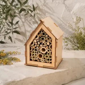 Hotel de insectos de madera con tejado inclinado y tubos naturales.
