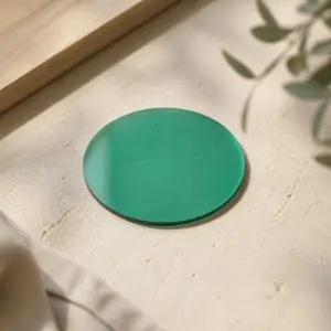 Posavasos circular de biomaterial verde sobre una superficie clara.