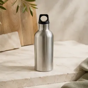 Botella térmica de acero inoxidable de 500 ml con tapón perforado en una composición de presentación sobre un fondo natural