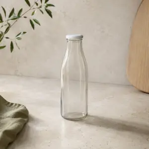 Botella de vidrio de 750 ml con tapa blanca en una composición de presentación sobre un fondo natural