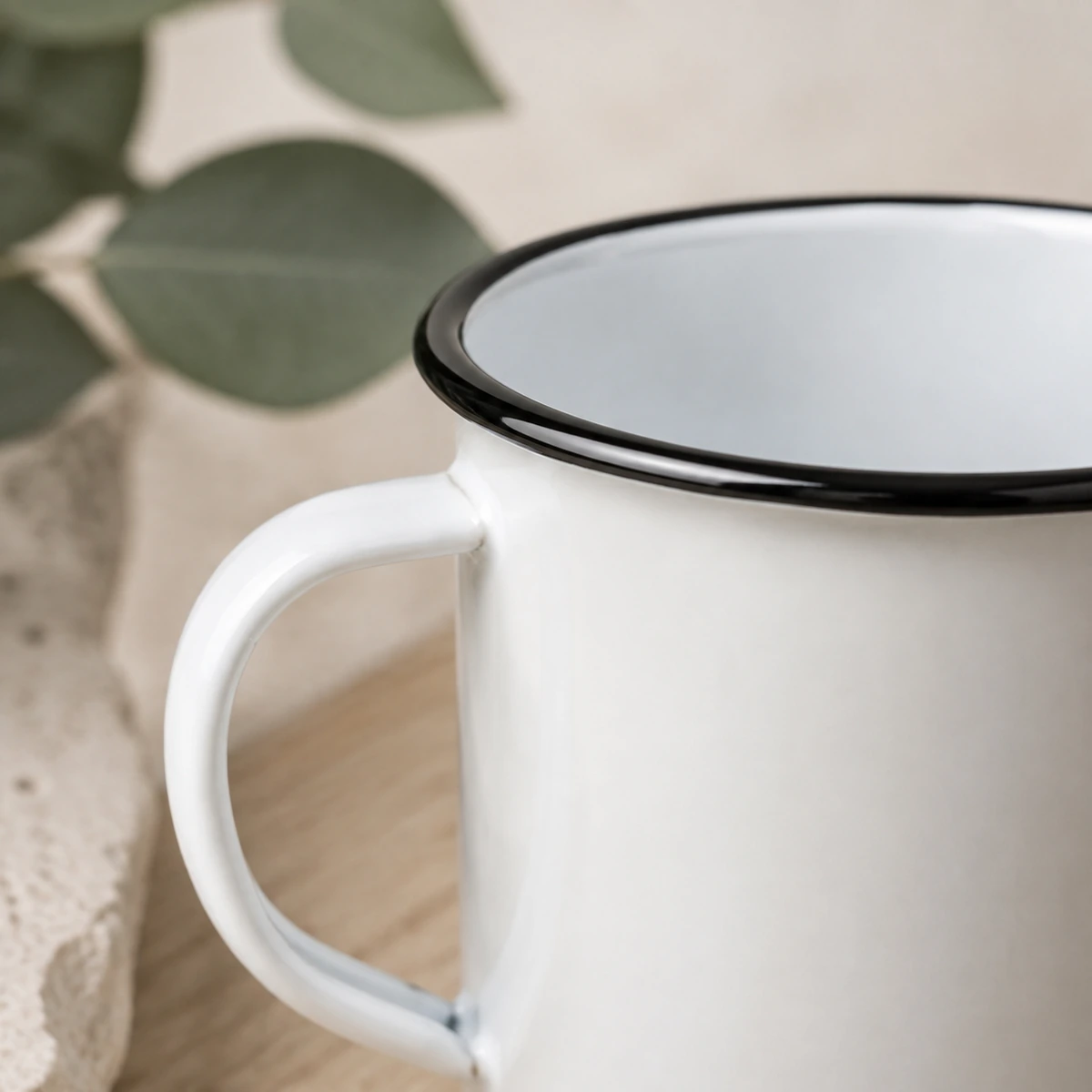 Taza de acero esmaltado de 400 ml con borde negro con detalle de sus materiales y acabado
