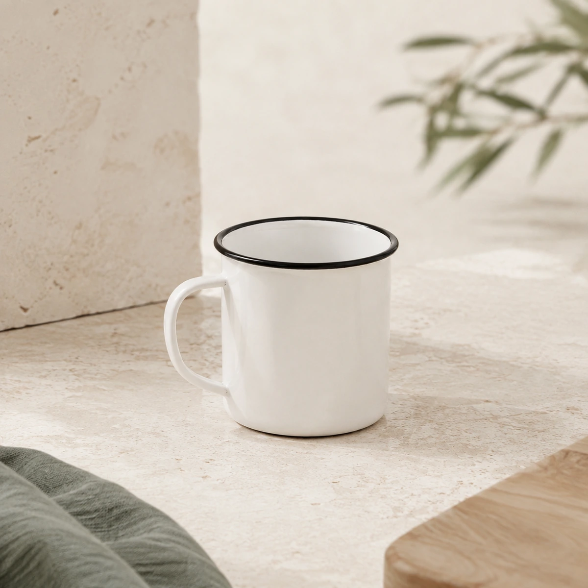 Taza de acero esmaltado de 400 ml con borde negro en una composición de presentación sobre un fondo natural