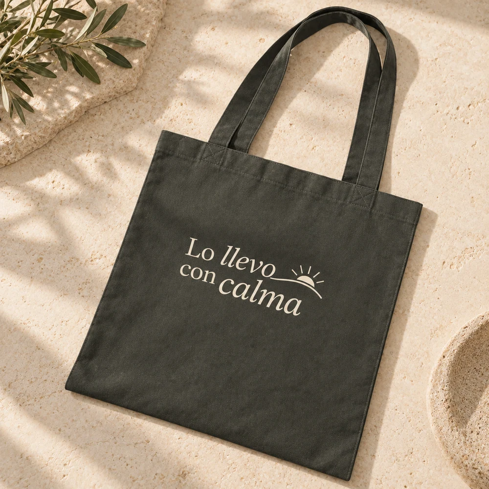Tote Alba khaki con una frase a una tinta clara, sobre una superficie de piedra.
